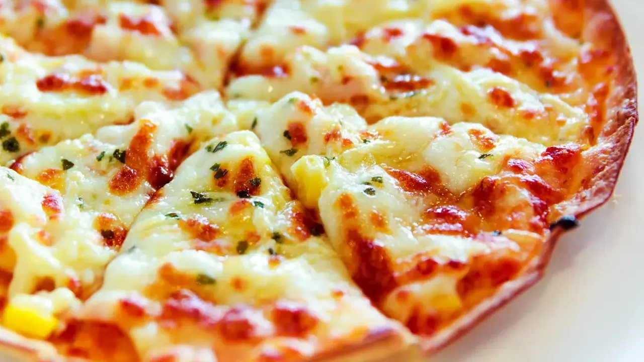 Pyszna, gorąca pizza z patelni, z ciągnącym się serem i ziołami, gotowa do podania.