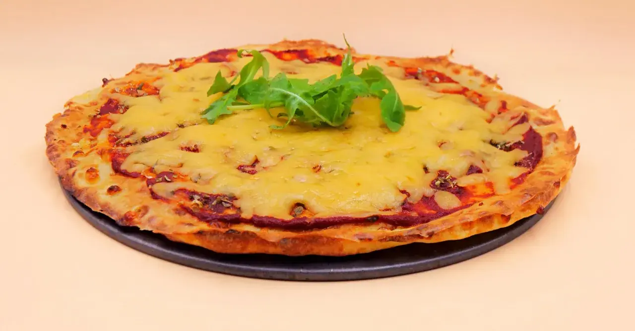Chrupiąca pizza z serka wiejskiego, pokryta ciągnącym się serem i świeżą rukolą. Idealna na szybki obiad.