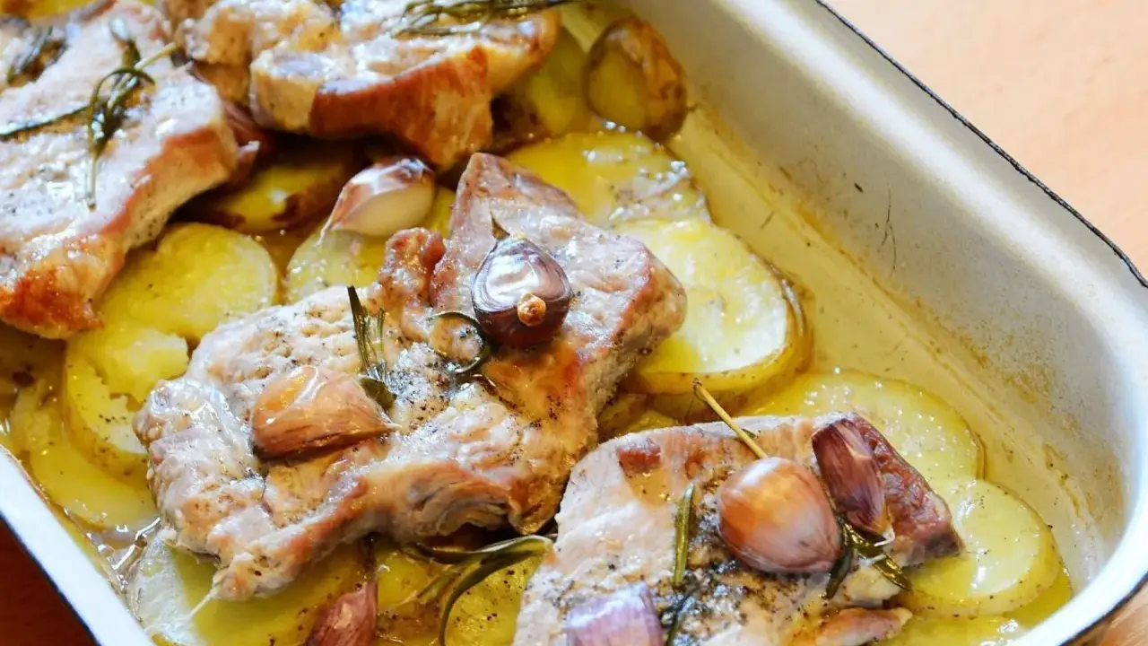 Rozpływająca się karkówka z piekarnika, pieczona z ziemniakami, czosnkiem i rozmarynem. Pyszne danie, które rozpływa się w ustach.