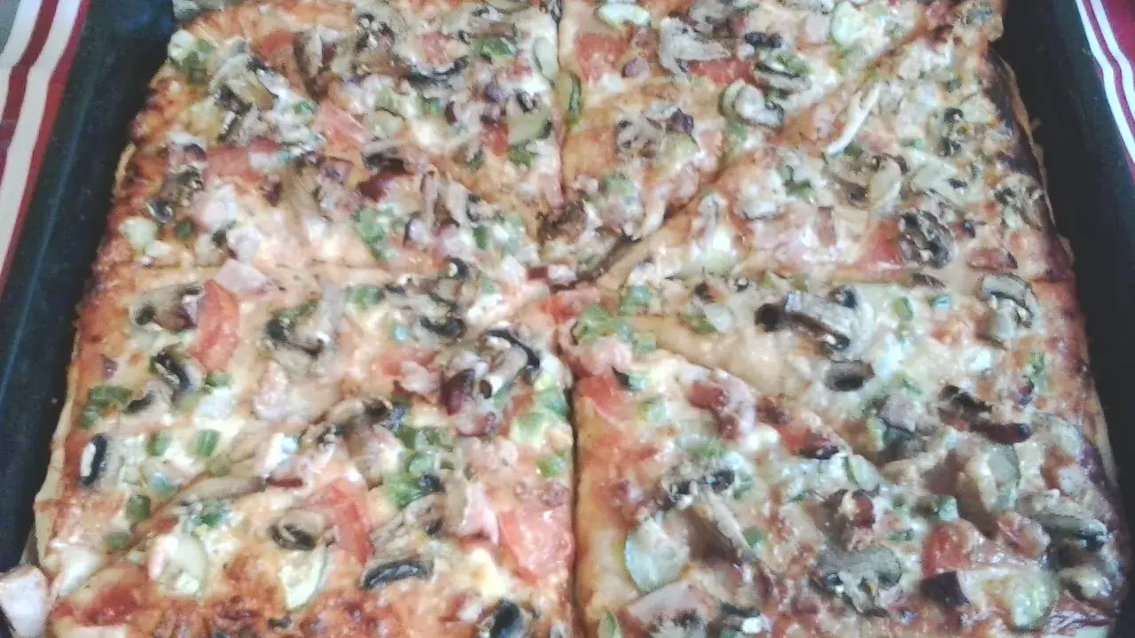 Pyszna pizza na grubym cieście z pieczarkami, pomidorami i papryką, prosto z blachy.