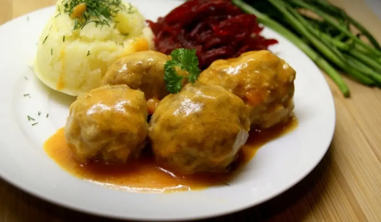 Pyszne pulpety w sosie pomidorowym, podane z puree ziemniaczanym, buraczkami i zielonymi warzywami.