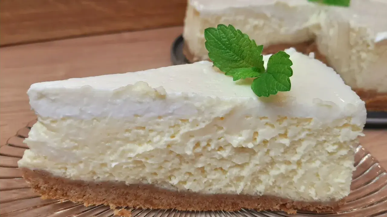 Pyszny sernik gotowany z wiaderka na kruchych herbatnikach, udekorowany listkiem mięty. Idealny deser na każdą okazję.