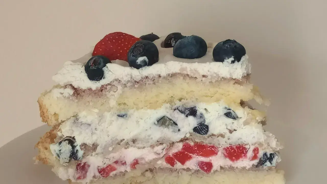 Pyszne ciasto na biszkopcie z bitą śmietaną, truskawkami i borówkami. Idealne na letnie popołudnie.