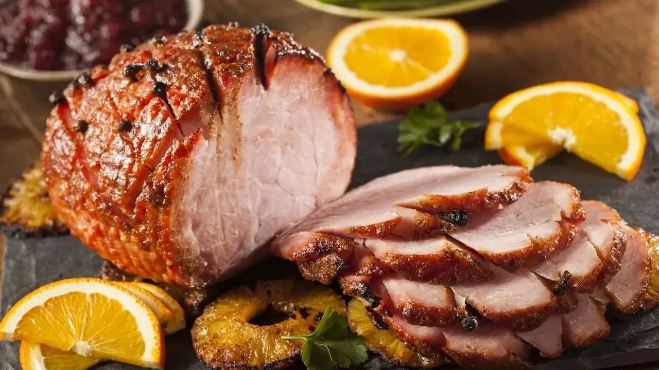 Pieczona szynka z pomarańczą i ananasem, idealna do świątecznego stołu. Marynata do szynki nadała jej piękny kolor i aromat.