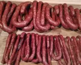 Dwie linie świeżo uwędzonej, prawdziwej wiejskiej kiełbasy, gotowe do podania. Przepis na domową kiełbasę jest w zasięgu ręki!