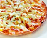 Pyszna, gorąca pizza z patelni, z ciągnącym się serem i ziołami, gotowa do podania.