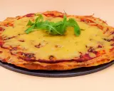 Chrupiąca pizza z serka wiejskiego, pokryta ciągnącym się serem i świeżą rukolą. Idealna na szybki obiad.