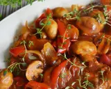Pyszny karczek po cygańsku z pieczarkami i papryką, duszony w aromatycznym sosie, udekorowany świeżym tymiankiem.