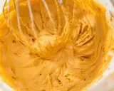 Mieszanie puszystego, złocistego kremu do tortu z mascarpone za pomocą trzepaczki miksera.