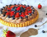 Pyszna tarta z owocami: kruchy spód, czekoladowy krem i świeże truskawki z borówkami. Idealna na deser!