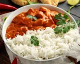 Aksamitny kurczak tikka masala w kremowym sosie, podany z puszystym ryżem i świeżą kolendrą.