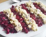 Pyszna sałatka śledziowa z burakiem, ziemniakami i majonezem, podana na białym talerzu.
