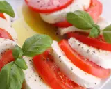 Sałatka z mozzarellą, pomidorami i bazylią, skropiona oliwą i pieprzem. Klasyczne połączenie smaków.