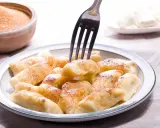 Pyszne kopytka z serem, posypane cynamonem i cukrem, gotowe do jedzenia. Idealne na deser lub obiad.