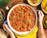 Pyszny butter chicken przepis w kremowym sosie, podany z ryżem, sałatką i chlebkiem naan.