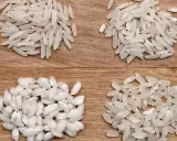 Cztery rodzaje ryżu do risotto ułożone na drewnianym tle.