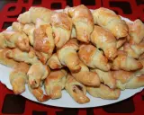 Stosik pysznych, błyszczących rogalików krucho drożdżowych, polanych lukrem. Idealne na deser lub do kawy.