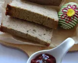 Domowy pasztet z kaczki, pokrojony w grube plastry, podany z żurawiną i ozdobnym jajkiem.