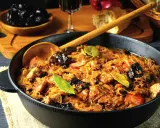 Ania gotuje pyszny bigos w żeliwnym naczyniu, pełen kapusty, mięsa i śliwek.