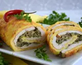 Rolada serowa z kurczakiem, grzybami i szpinakiem, ozdobiona papryczką chili i natką pietruszki.