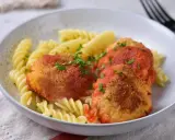 Elegancki obiad dla gości: pulpeciki w sosie pomidorowym z makaronem fusilli, posypane natką pietruszki.