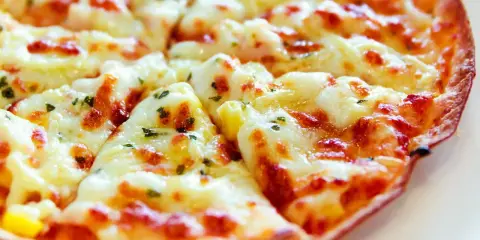 Pyszna, gorąca pizza z patelni, z ciągnącym się serem i ziołami, gotowa do podania.