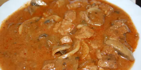 Pyszny strogonow z wieprzowiny i pieczarek w kremowym sosie. Aromatyczne kawałki mięsa i grzybów w bogatym, pomidorowym sosie.