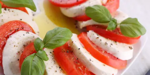 Sałatka z mozzarellą, pomidorami i bazylią, skropiona oliwą i pieprzem. Klasyczne połączenie smaków.