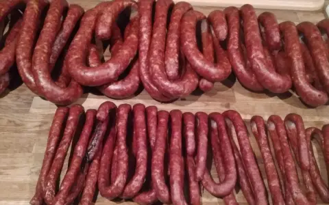 Dwie linie świeżo uwędzonej, prawdziwej wiejskiej kiełbasy, gotowe do podania. Przepis na domową kiełbasę jest w zasięgu ręki!