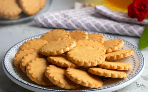 Stos ciasteczek na talerzu, idealnych do kawy. Prosty przepis na ciasteczka, który każdy może wypróbować.