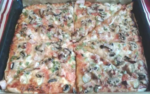 Pyszna pizza na grubym cieście z pieczarkami, pomidorami i papryką, prosto z blachy.