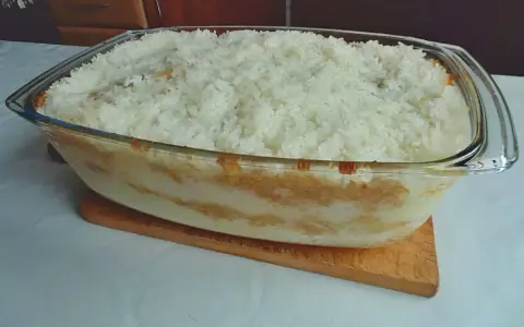 Pyszny, domowy ryż z jabłkami w szklanej formie, gotowy do pieczenia.
