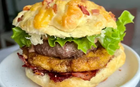 Pyszny burger drwala przepis: soczysty kotlet, chrupiący bekon, ser i świeża sałata w puszystej bułce.