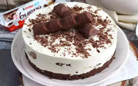 Pyszny tort Kinder Bueno, udekorowany czekoladowymi wiórkami i batonikami. Idealny na każdą okazję!