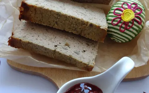 Domowy pasztet z kaczki, pokrojony w grube plastry, podany z żurawiną i ozdobnym jajkiem.