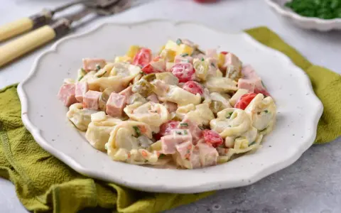 Pyszna sałatka z tortellini, szynki, pomidorków i ogórków konserwowych w kremowym sosie. Idealna na każdą okazję.