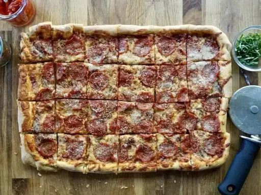 Domowa pizza na blachę z pepperoni, idealna na rodzinne spotkanie. Przepis na blachę jest prosty i szybki.