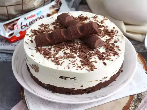 Pyszny tort Kinder Bueno, udekorowany czekoladowymi wiórkami i batonikami. Idealny na każdą okazję!