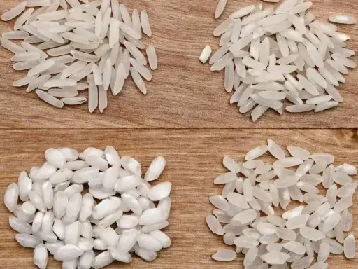 Cztery rodzaje ryżu do risotto ułożone na drewnianym tle.