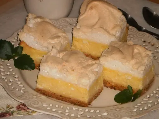 Pyszny sernik z bezą na kruchym spodzie, udekorowany listkami mięty. Idealny na deser.