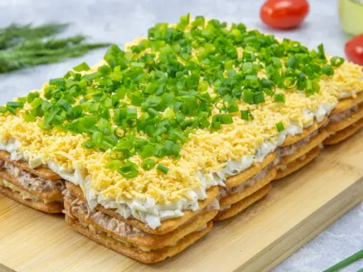 Warstwowa sałatka na krakersach z jajkiem, majonezem i szczypiorkiem. Pyszna przekąska na każdą okazję.