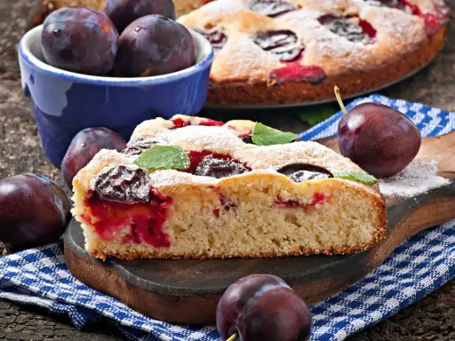 Pyszne ciasto z owocami, z soczystymi śliwkami, posypane cukrem pudrem. Idealne na deser.