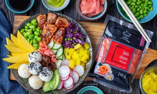 Kolorowy bowl z lososiem, ryżowymi kulkami, mango, awokado, edamame i marynowanym imbirem. Obok opakowanie różowego imbiru.