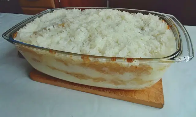 Pyszny, domowy ryż z jabłkami w szklanej formie, gotowy do pieczenia.