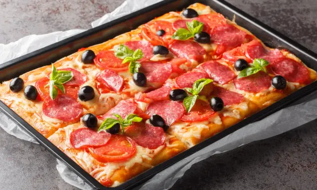 Chrupiąca pizza z ciasta francuskiego z salami, pomidorami, oliwkami i bazylią, prosto z blachy.