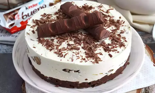 Pyszny tort Kinder Bueno, udekorowany czekoladowymi wiórkami i batonikami. Idealny na każdą okazję!
