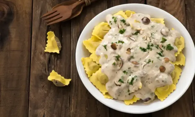 Pyszne ravioli w kremowym sosie śmietanowym z grzybami i natką pietruszki. Idealny sos śmietanowy do makaronu.