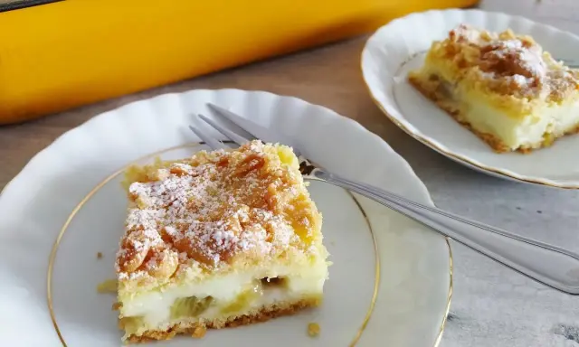 Pyszne ciasto z rabarbarem i budyniem, posypane cukrem pudrem, czeka na talerzyku. Idealne na deser!