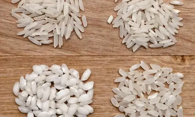 Cztery rodzaje ryżu do risotto ułożone na drewnianym tle.