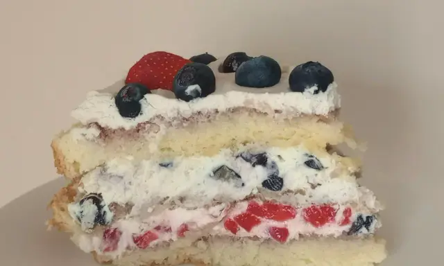 Pyszne ciasto na biszkopcie z bitą śmietaną, truskawkami i borówkami. Idealne na letnie popołudnie.